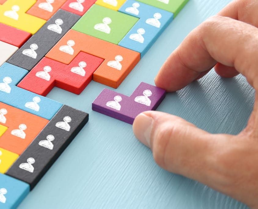 image of tangram puzzle blocks with people icons over wooden table ,human resources and management concept.